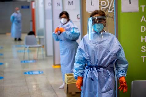 Health workers wait for passengers arriving from high-risk countries to carry out rapid antigenic tests for Covid-19 at a testing station in Rome Airport